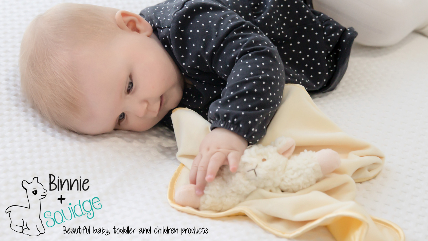 Baby lying with snuggly lamb blankie